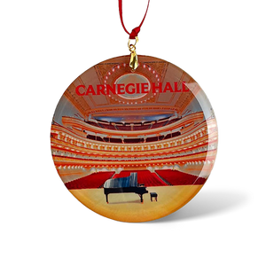 A glass ornament featuring a piano on a stage. 