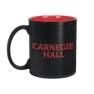 A black mug with red interior, with the words "Carnegie Hall" in red. 