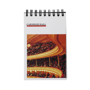 A small flip notepad with a white background and a picture of the audience in Stern Auditorium a a Carnegie Hall retro logo on the top left.